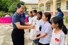 Bà Ksor H'Khuyên-Phó Chủ tịch UBND thị xã tặng quà cho các em học sinh có hoàn cảnh khó khăn nhân dịp Tết Trung thu. Ảnh: Vũ Chi